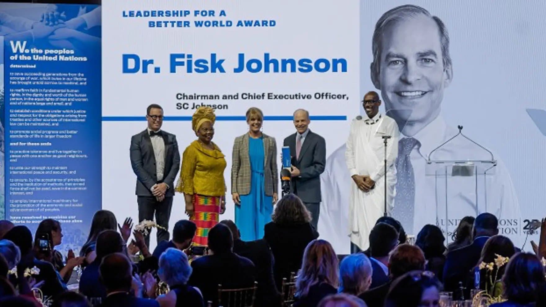 A group of five people stand on stage posing for a photo at an event. Text reads: "Leadership for a Better World Award. Dr. Fisk Johnson, Chairman and Chief Executive Officer, SC Johnson."